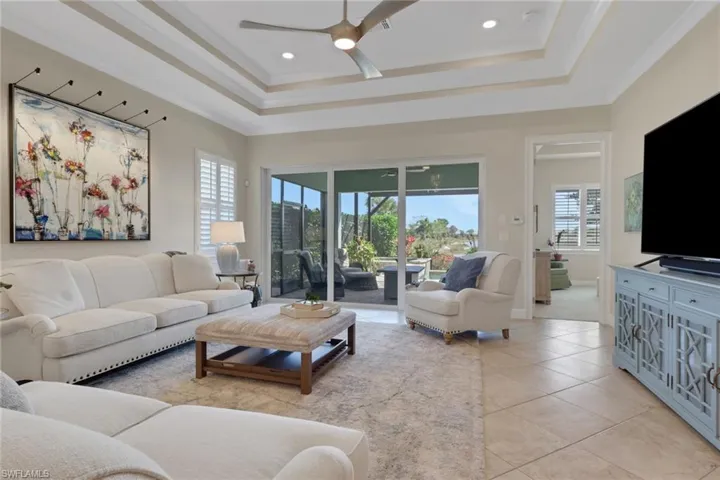 Living area with a ceiling fan, light tile patterned floors, ornamental molding, and recessed lighting