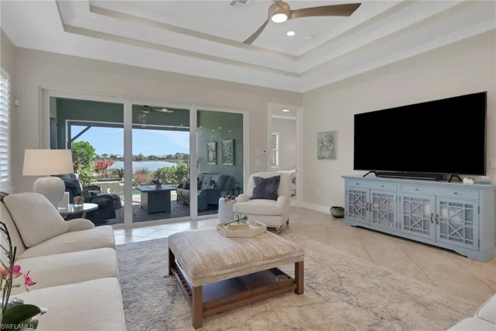 Living room featuring ceiling fan, light tile patterned floors, and ornamental molding