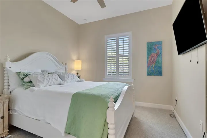 Bedroom with light colored carpet and ceiling fan