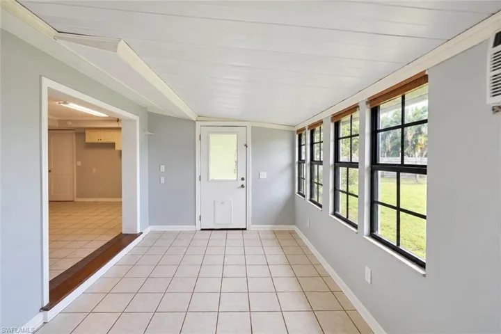 Concrete flooring in garage with built-in shelving, white cabinetry, and a water heater