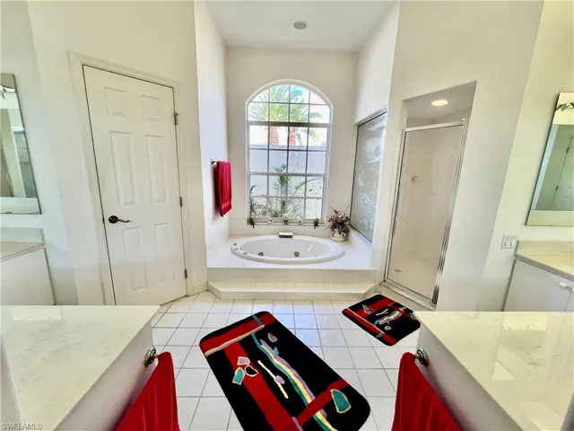 Primary bathroom with dual sinks and vanities, jetted tub and separate shower.