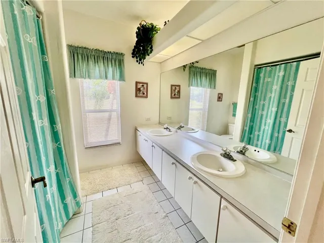 Bathroom featuring a wealth of natural light, tile patterned flooring, and a sink