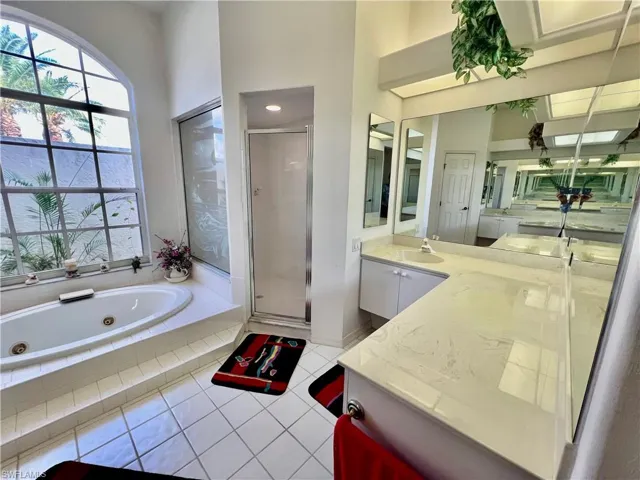 Primary bathroom with dual sinks and vanities, jetted tub and separate shower.