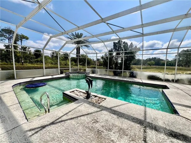 View of swimming pool featuring a patio area, a lanai, and a pool with connected hot tub