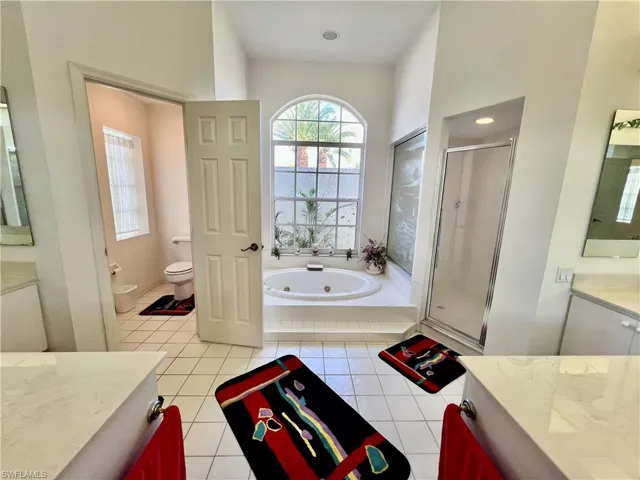 Primary bathroom with dual sinks and vanities, jetted tub and separate shower.