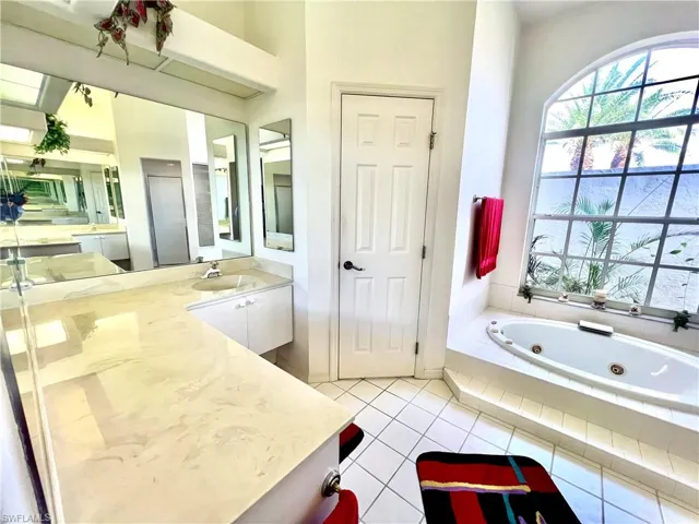 Primary bathroom with dual sinks and vanities, jetted tub and separate shower.