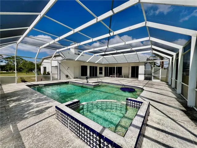 View of pool featuring a pool with connected hot tub, a lanai, and a patio