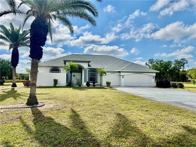 View of front of property with a TRIPLE garage and extra long driveway with plenty of parking.