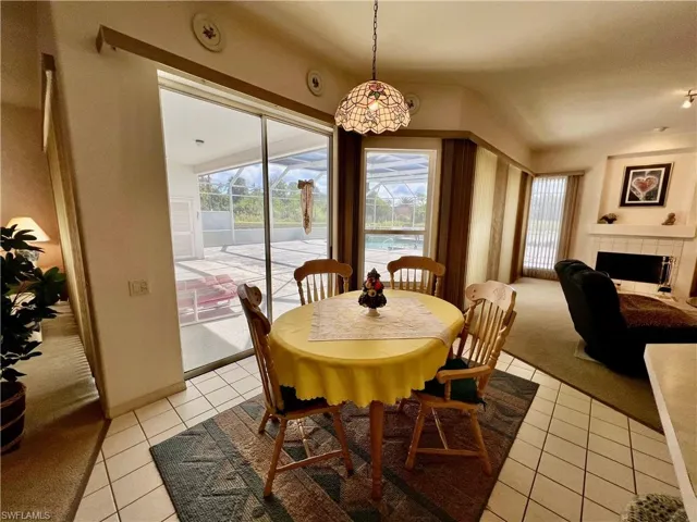 Breakfast nook area featuring a wealth of natural light, visible vents, and light tile patterned floors and views of the pool.