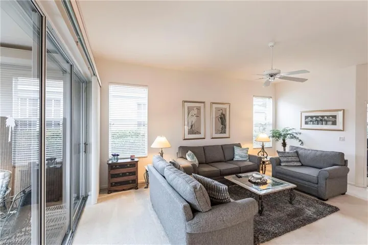 Carpeted living room featuring ceiling fan