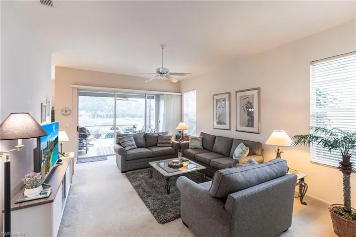 Living room with light colored carpet and ceiling fan