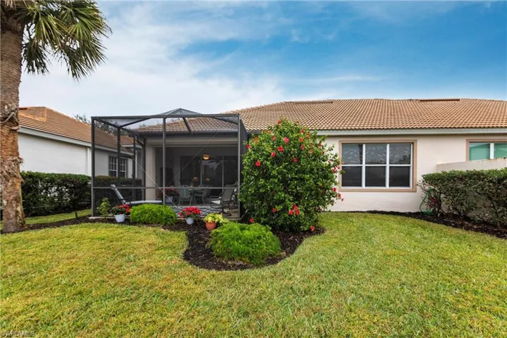 Back of house featuring a lanai and a lawn