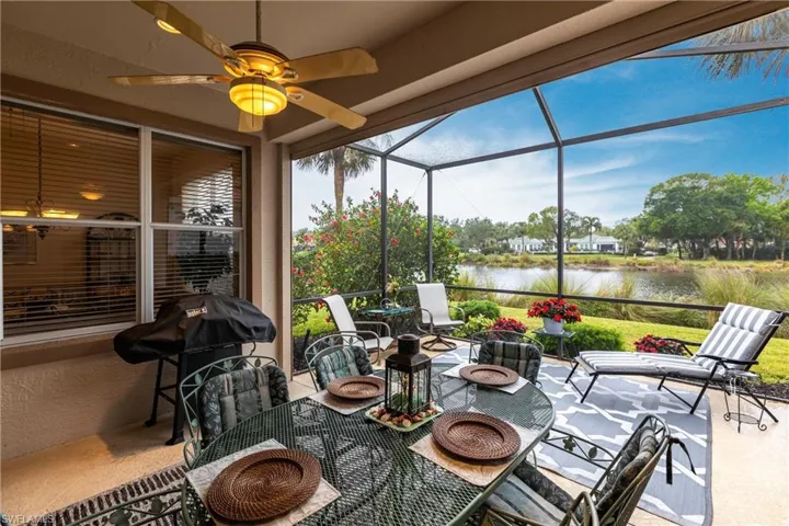 Sunroom with ceiling fan and a water view