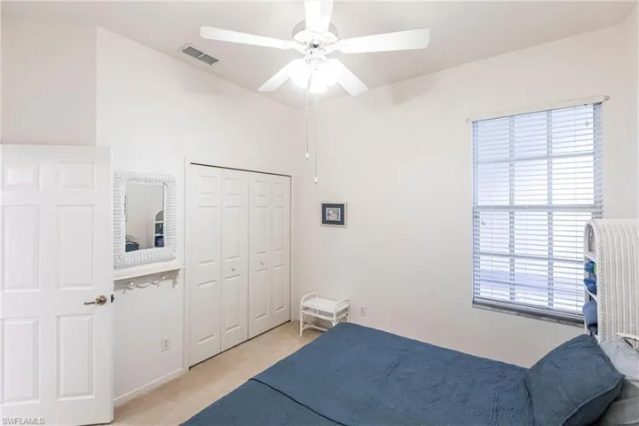 Carpeted bedroom with a closet and ceiling fan