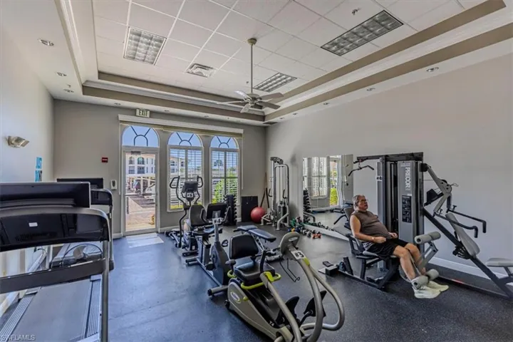 Gym with ceiling fan and crown molding