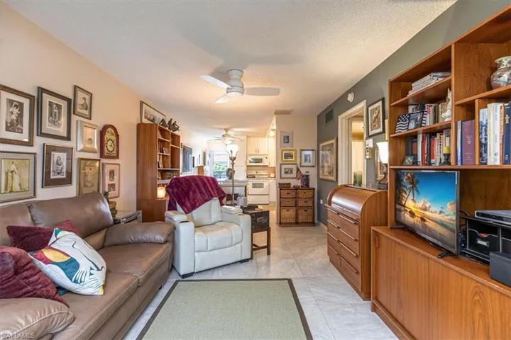 Sitting room with a ceiling fan and a textured ceiling