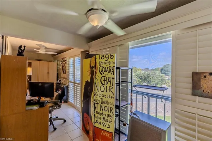 Office with a ceiling fan and light tile patterned flooring