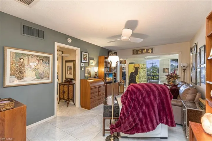 Living area with a ceiling fan and a textured ceiling