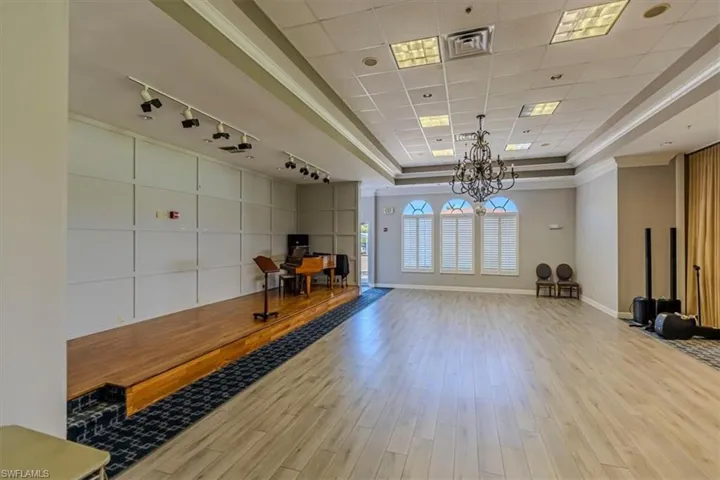 Exercise room with suspended lighting and a raised ceiling