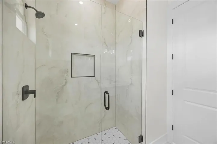 Full bath with a marble finish shower