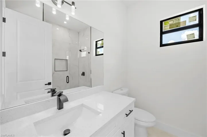 Bathroom with a marble finish shower and vanity