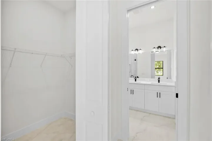Bathroom featuring a walk in closet and double vanity
