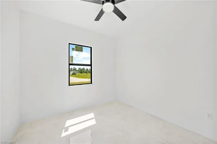 Empty room featuring baseboards and a ceiling fan