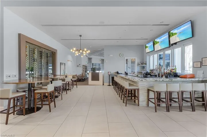 Dining room with a chandelier, plenty of natural light, a towering ceiling, and tile patterned floors