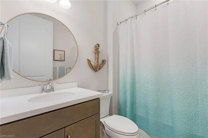 Full bathroom featuring toilet, vanity, and curtained shower