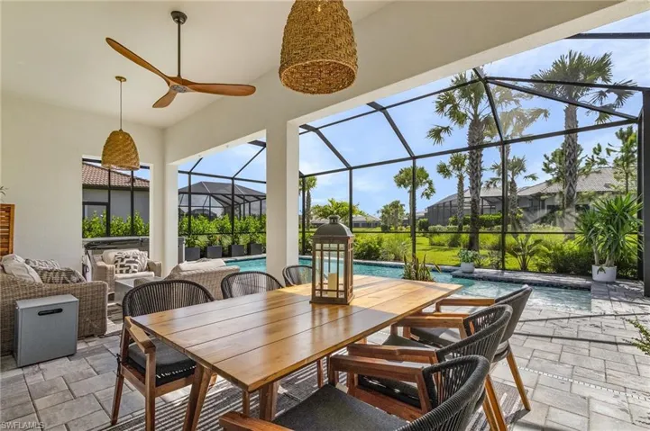 View of patio / terrace featuring an outdoor pool, outdoor dining space, ceiling fan, and a lanai