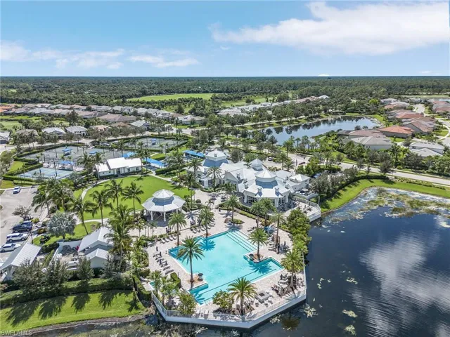 Aerial perspective of suburban area featuring a nearby body of water and a pool area