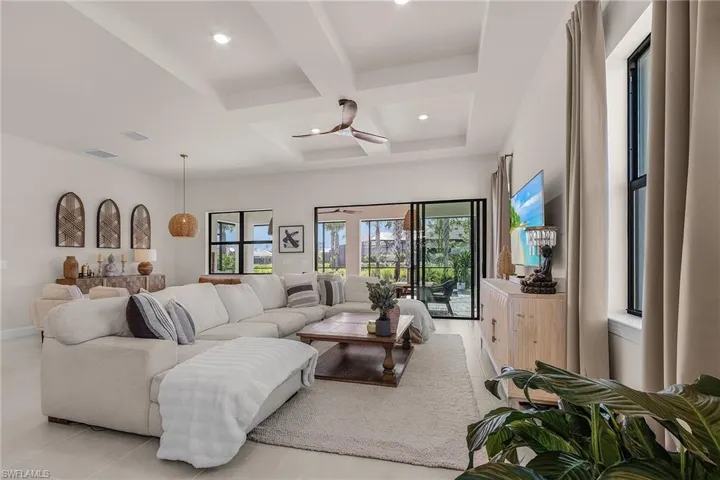 Living room featuring coffered ceiling, light tile patterned flooring, recessed lighting, beamed ceiling, and a ceiling fan