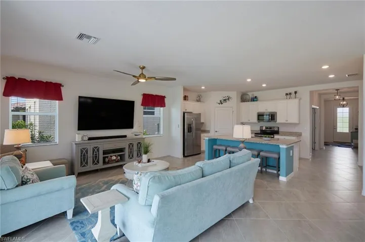 Living area featuring light tile patterned flooring, ceiling fan, visible vents, and recessed lighting