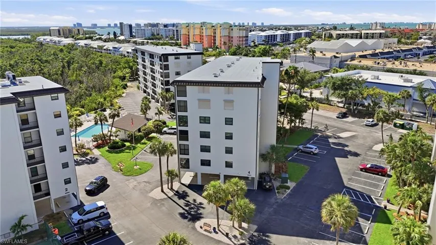 Multi-story condominium building featuring a white facade and dark trim - Virtually Edited Image