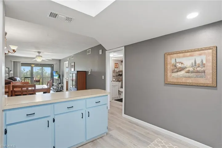 Functional kitchen pass-through with light blue cabinetry and light-toned countertop - Virtually Edited Image
