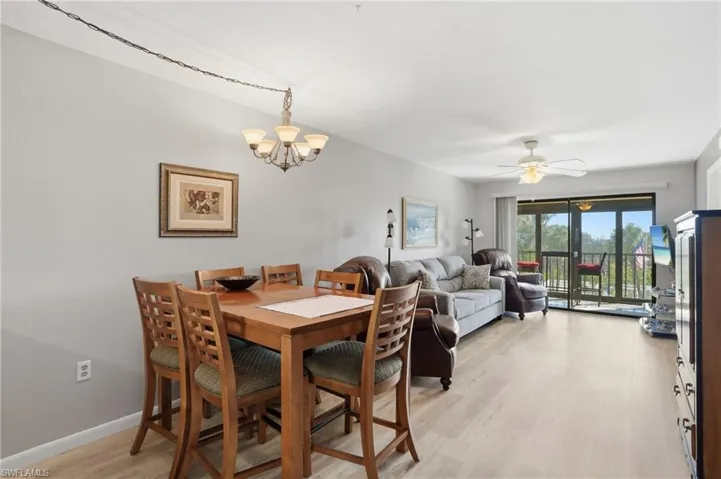 Open-concept living and dining area featuring light-toned wood-finish flooring - Virtually Edited Image