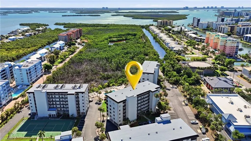 Multi-story building with multiple balconies, positioned near extensive waterways - Virtually Edited Image