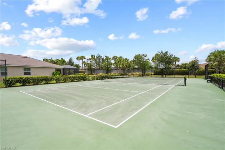 Full-size tennis court featuring a net and white court lines