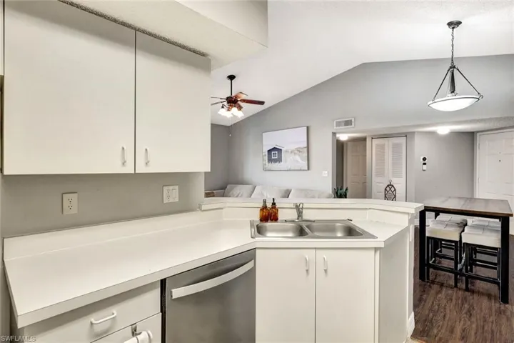 Kitchen with sink, white cabinets, dishwasher, and kitchen peninsula