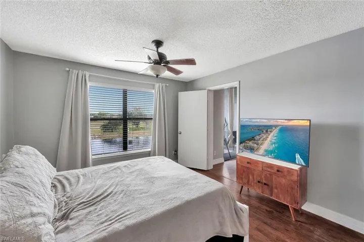 Bedroom featuring ceiling fan, a textured ceiling, and dark hardwood / wood-style flooring