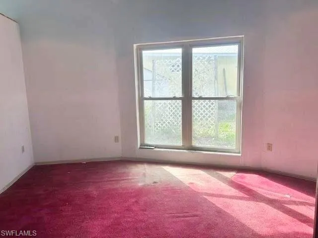 Room featuring a prominent window, wall-to-wall carpeting, and painted walls