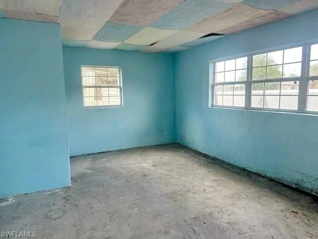 Room featuring light blue painted walls, a large multi-pane window, and a smaller single-pane window