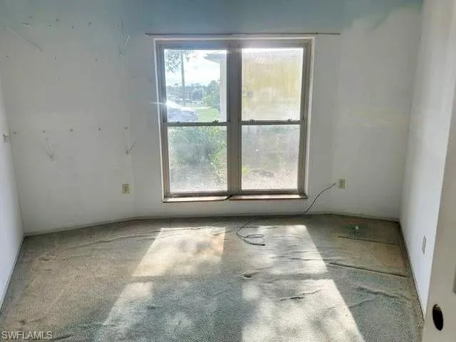 Room featuring a double-hung window with wood-frame construction and a power outlet