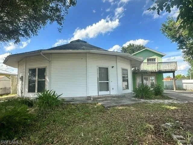 Unique octagonal structure featuring white siding and a dark shingle roof