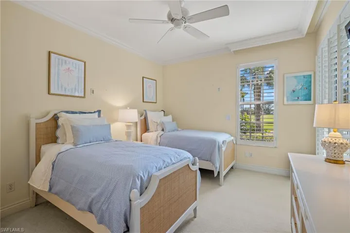 Bedroom with crown molding, light colored carpet, and a ceiling fan