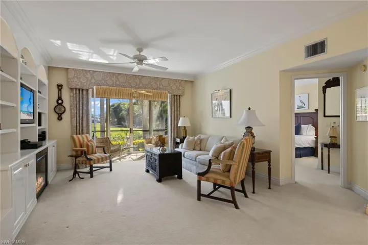 Living room with crown molding, light carpet, and ceiling fan