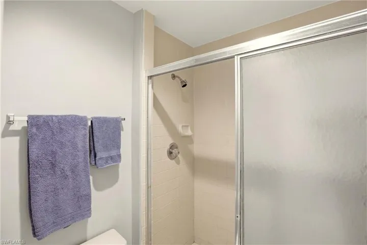 Full bathroom featuring a stall shower and toilet