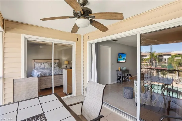 Tiled bedroom with a closet, wood walls, a ceiling fan, and access to outside