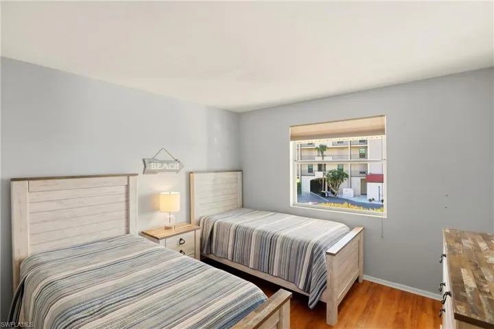 Bedroom with wood finished floors and baseboards