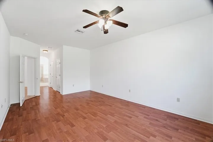 Primary Bedroom with wood look flooring and two walk in closets.